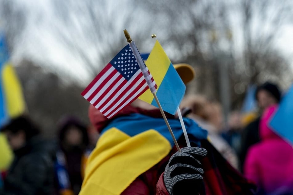 A protester holds US and Ukrainian flags in front of the White House in Washington DC.