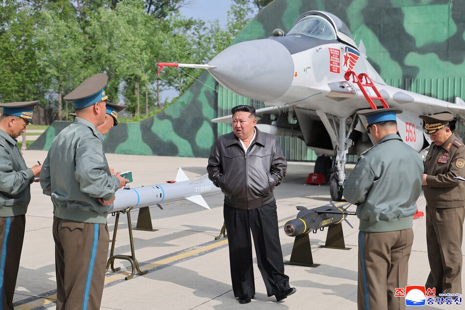 Kim Jong Un (41), Machthaber von Nordkorea, vor einem Kampfjet und verschiedenen Raketen. Der Diktator schwört seine Gefolgsleute auf einen "echten krieg" ein. (Archivfoto)