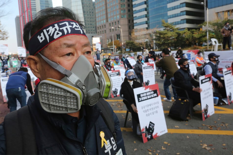 Seoul: Ein Mann mit Mund-Nasen-Schutz nimmt an einer Kundgebung teil, auf der Arbeiter für bessere Arbeitsbedingungen demonstrieren.