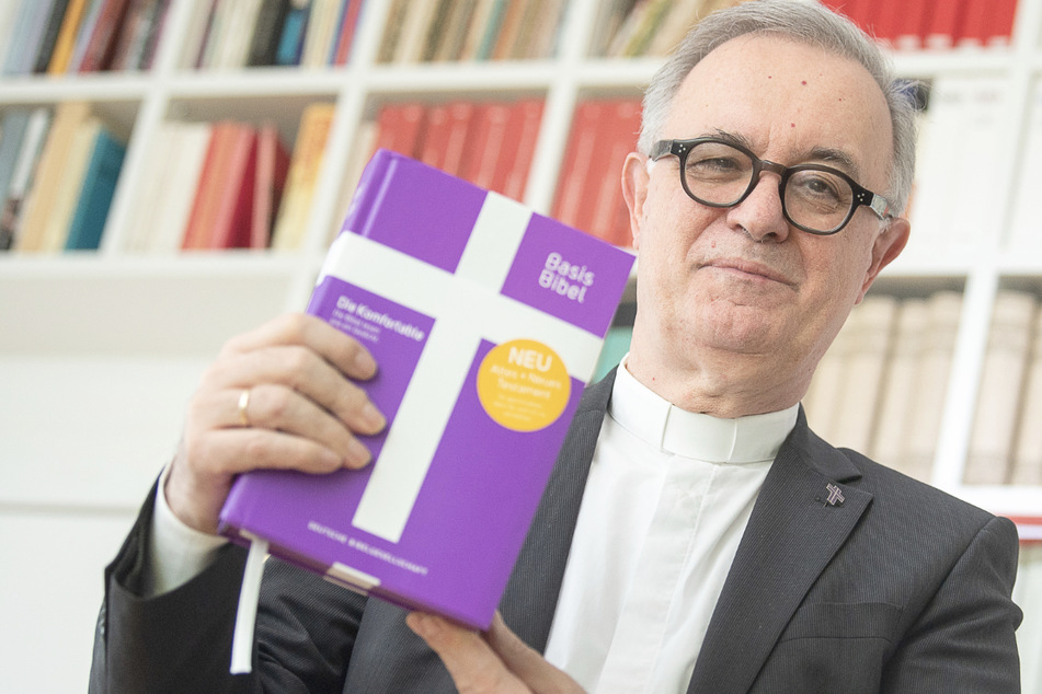 Frank Otfried July (66), Landesbischof der Evangelischen Kirche in Württemberg, hält eine Ausgabe der "BasisBibel" in der Hand.