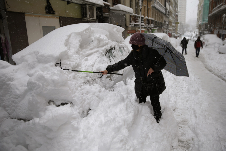 Eine Frau in Madrid befreit ihr Auto von einer hohen Schneeschicht. Laut des Wetterdienstes AEMET gab es solch einen Schneefall das letzte Mal im Februar 1984.
