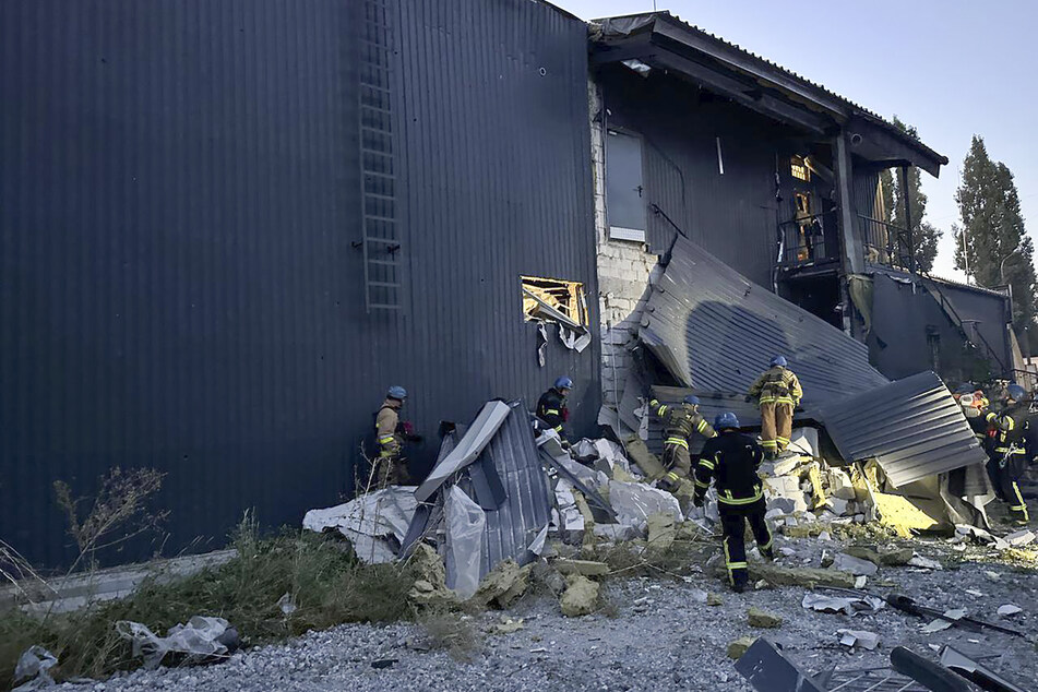 Rettungskräfte arbeiten an einem Gebäude in Saporischschja, das nach Raketeneinschlägen beschädigt wurde.