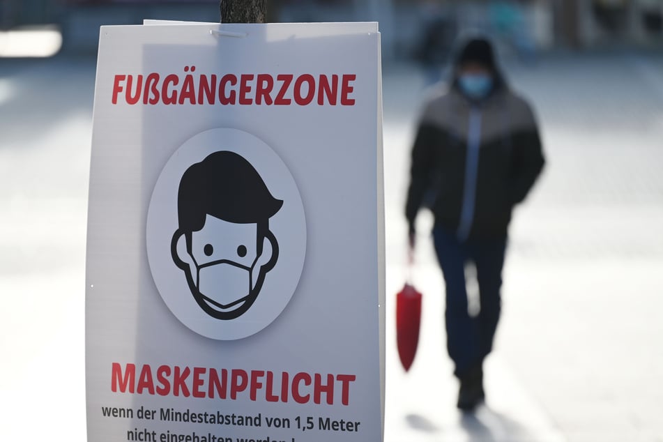 Ein Bild weist auf die Maskenpflicht in einer Fußgängerzone hin. (Archivfoto)