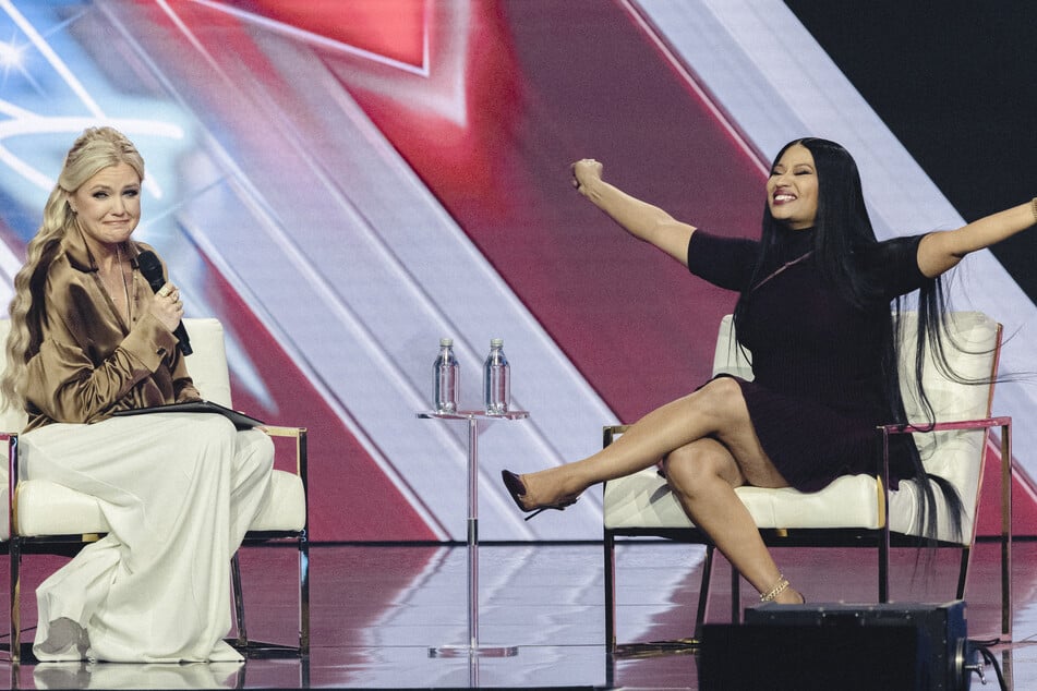 CEO and Chair of the Board of Turning Point USA Erika Kirk (l) speaks with rapper Nicki Minaj (r) during Turning Point's annual AmericaFest conference in Phoenix, Arizona on Sunday.