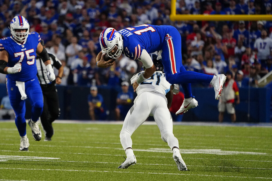 Buffalo Bills quarterback Josh Allen (top) jumped over Tennessee Titans cornerback Roger McCreary, running with the ball during the first half at Highmark Stadium on Monday night.