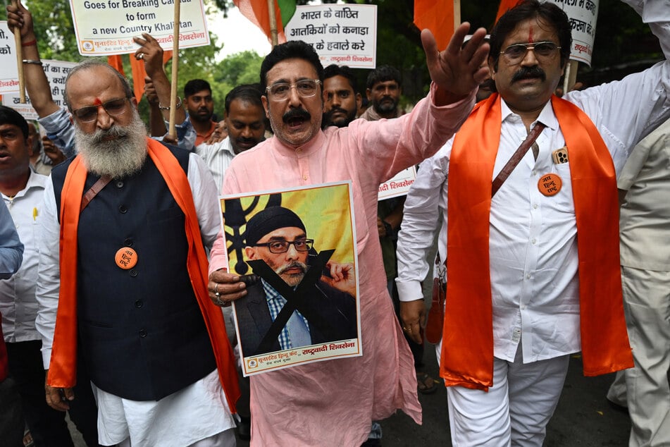 A member of United Hindu Front organization shouts slogans while holding a banner depicting Gurpatwant Singh Pannun during a rally along a street in New Delhi on September 24, 2023.