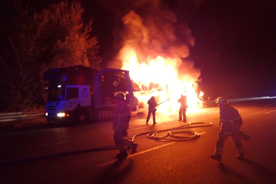 Feuerwehrleute versuchen, einen brennenden Lastwagen auf der A3 bei Regensburg zu löschen.