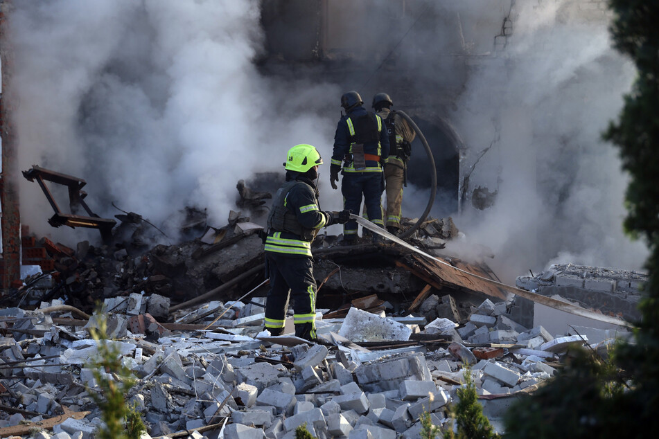 Ukrainische Feuerwehrleute kämpfen nach einer Raketen-Attacke gegen die Flammen.