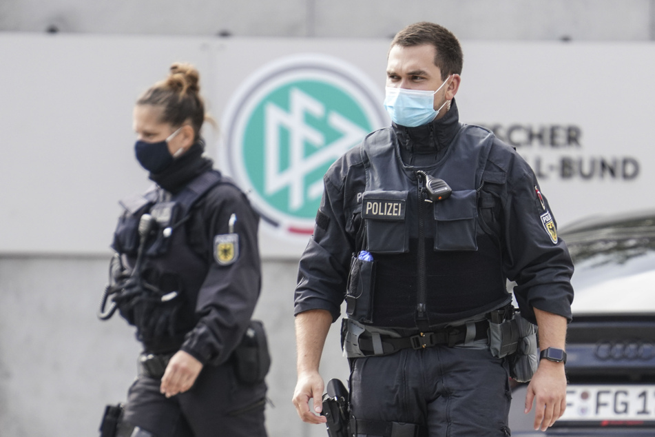 Polizisten gehen vor der Zentrale des Deutschen Fußball-Bundes (DFB) zu ihren Fahrzeugen.