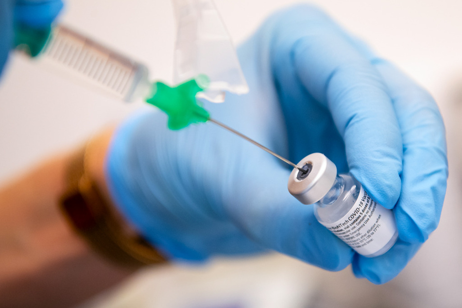 Eine Klinik-Mitarbeiterin zieht den Covid-19-Impfstoff von Biontech/Pfizer für eine Impfung auf eine Spritze.