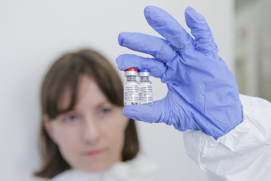 Eine Mitarbeiterin des Nikolai Gamaleya Nationalzentrums für Epidemiologie und Mikrobiologie hält zwei Ampullen mit einem neuen Impfstoff gegen das Coronavirus in ihrer Hand.