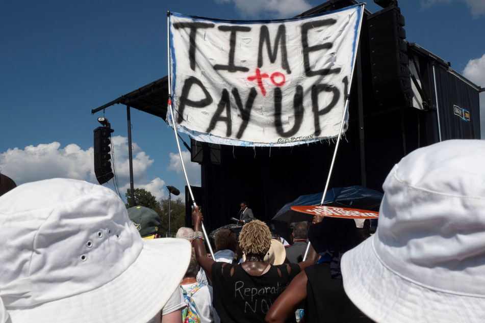 A participant at the 60th anniversary of the 1963 March on Washington calls for reparations for Black Americans.