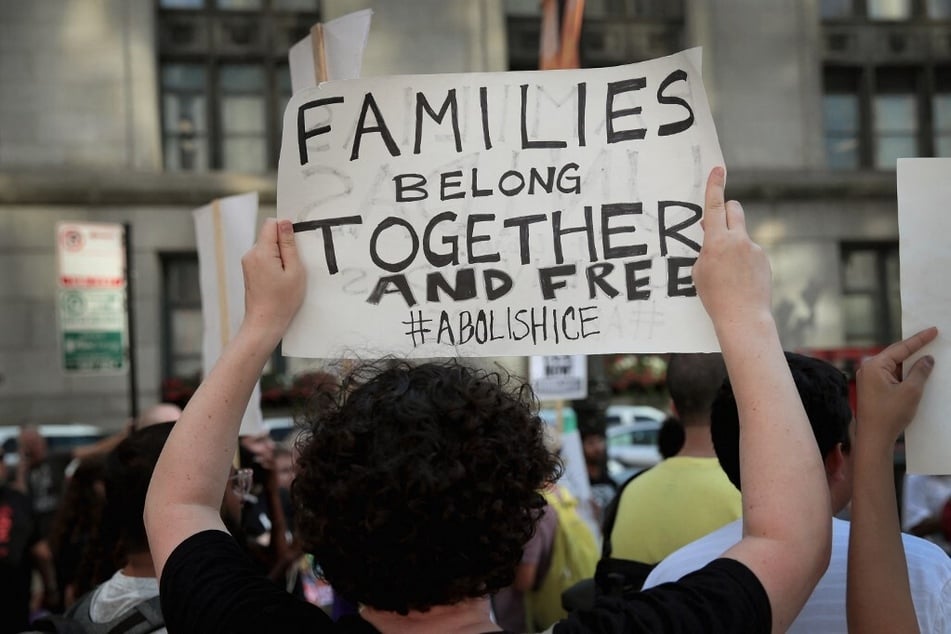 A demonstrator raises a sign reading "Families Belong Together and Free" during a protest in Chicago, Illinois, calling for the abolition of US Immigration and Customs Enforcement.