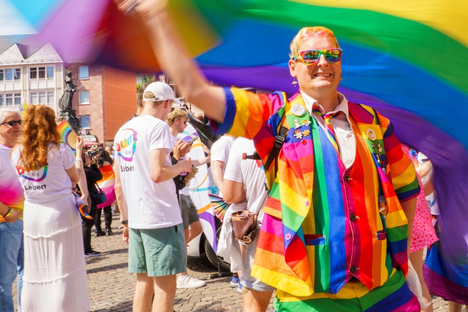 Ein CSD-Teilnehmer schwang einen Schirm mit einer Fahne in Regenbogenfarben.
