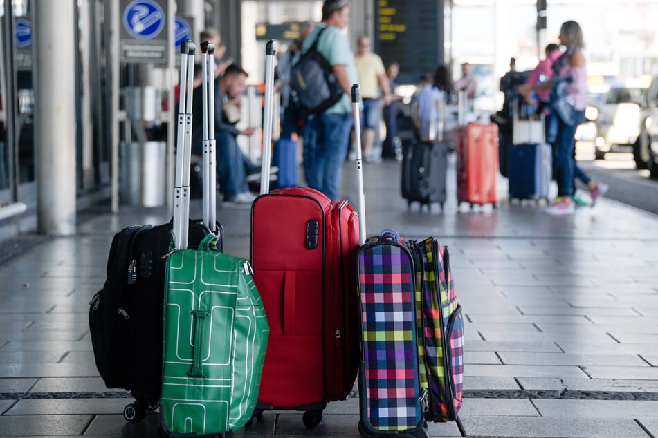 Hamburg: Fluggäste warten am Eingang zum Helmut-Schmidt-Airport neben ihrem Gepäck.