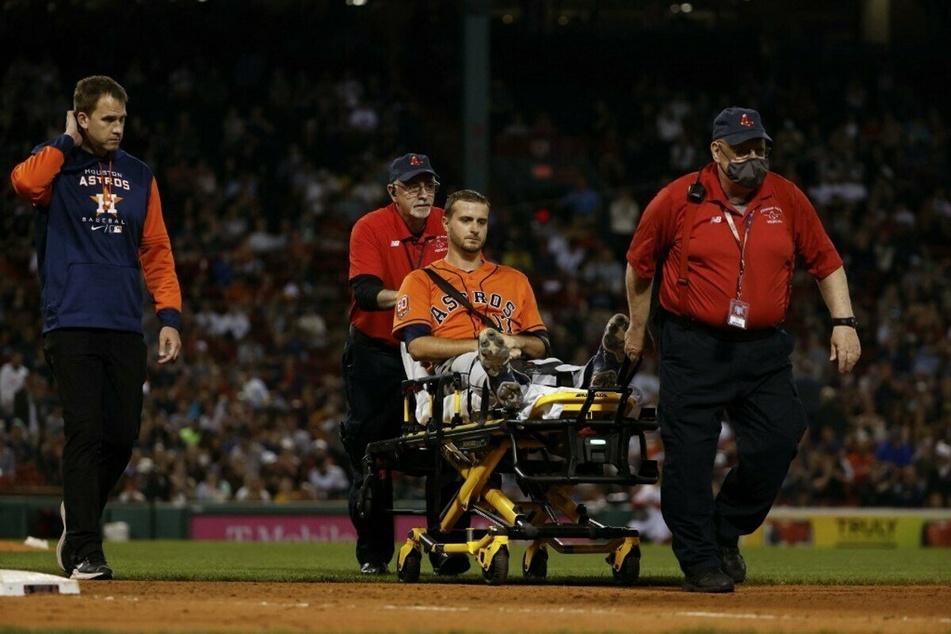 Pitcher Jake Odorizzi of the Houston Astros was taken off the field on a stretcher by medical personnel after sustaining an injury trying to get off the mound to cover first base on a ground out by Enrique Hernandez, during the sixth inning at Fenway Park on Monday.