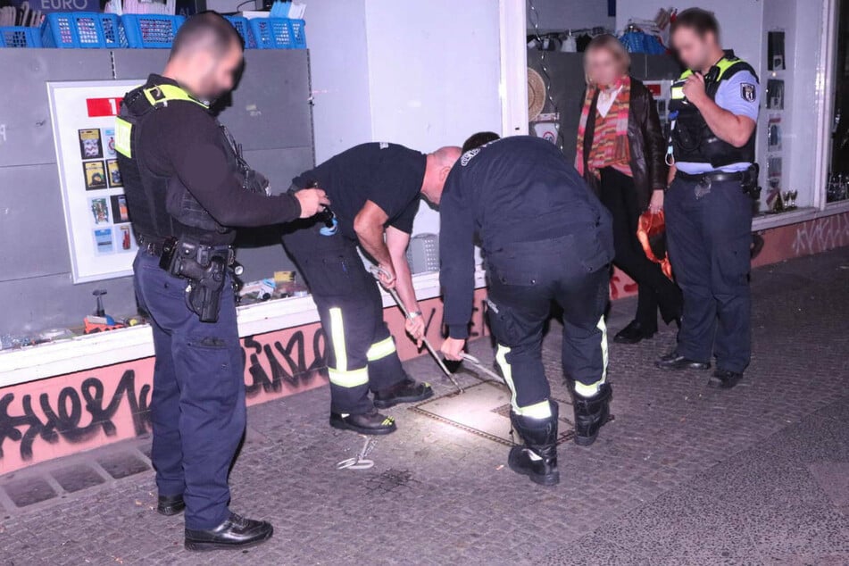 Eine junge Frau (2 .v.r.) hat ihr gestohlenes Handy in der Nacht zu Donnerstag unter einem Schachtdeckel in Berlin-Neukölln geortet und die Polizei informiert.
