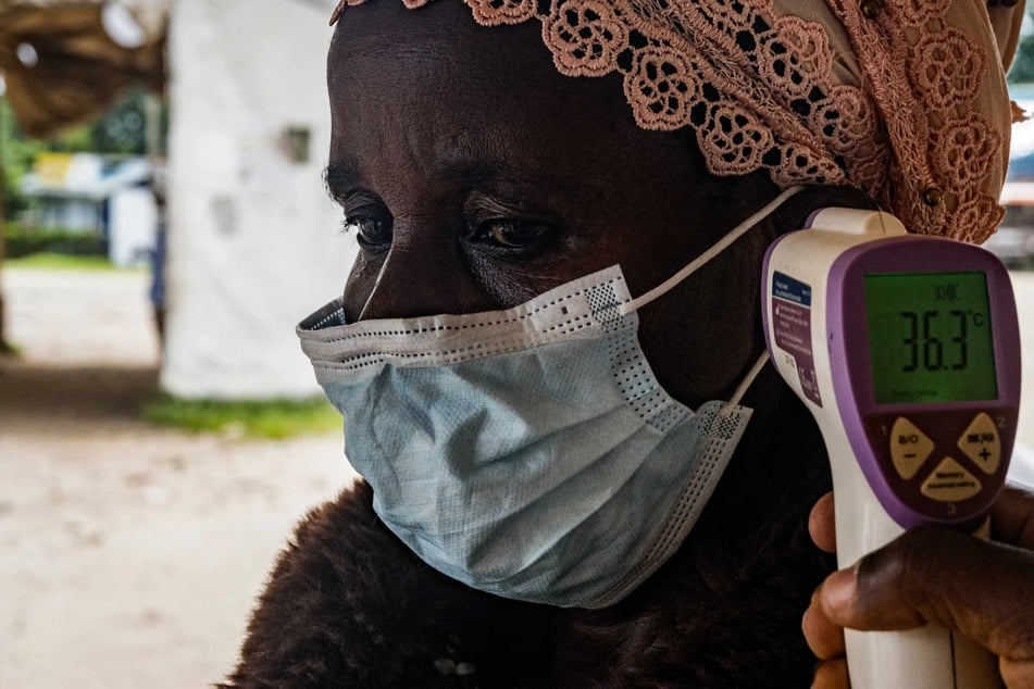 A border health officer at the Busunga crossing between Uganda and the Democratic Republic of Congo checks a traveler’s temperature using a contactless infrared thermometer in Bundibugyo, on Monday.