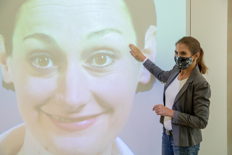 Luna Mittig erläutert Details zur Mimik und Gestik an einer Videoinstallation im Museum für Kommunikation.