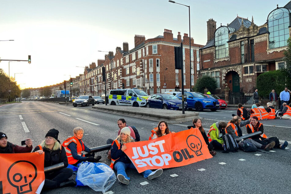 Aktivisten von Just Stop Oil blockieren eine Straße am Barons Court im Westen Londons.