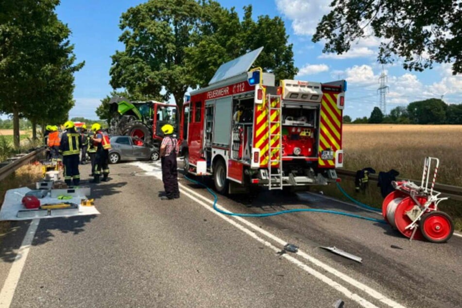 Die Feuerwehr musste einen Spezialkran einsetzen, um den auf dem Auto stehenden Traktor anzuheben und den Fahrer zu befreien.