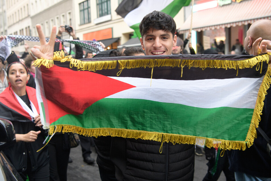Einer der Teilnehmer hält eine palästinensische Flagge hoch.