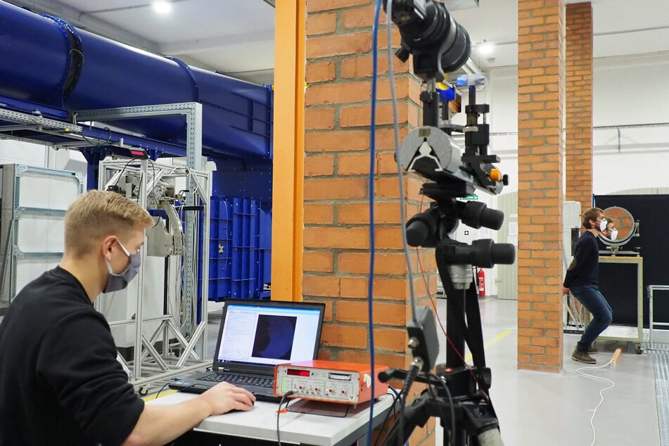 Moritz Kluwe (l.) und Emanuel Thom von der TU Freiberg nehmen das Maskentest-Video in der Versuchshalle der Professur für Strömungsmechanik auf.
