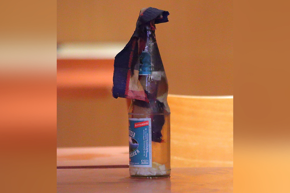 Der Molotow-Cocktail, gebastelt aus einer leeren Flasche Mineralwasser, die mit Grillanzünder und Lampenöl gefüllt wurde.