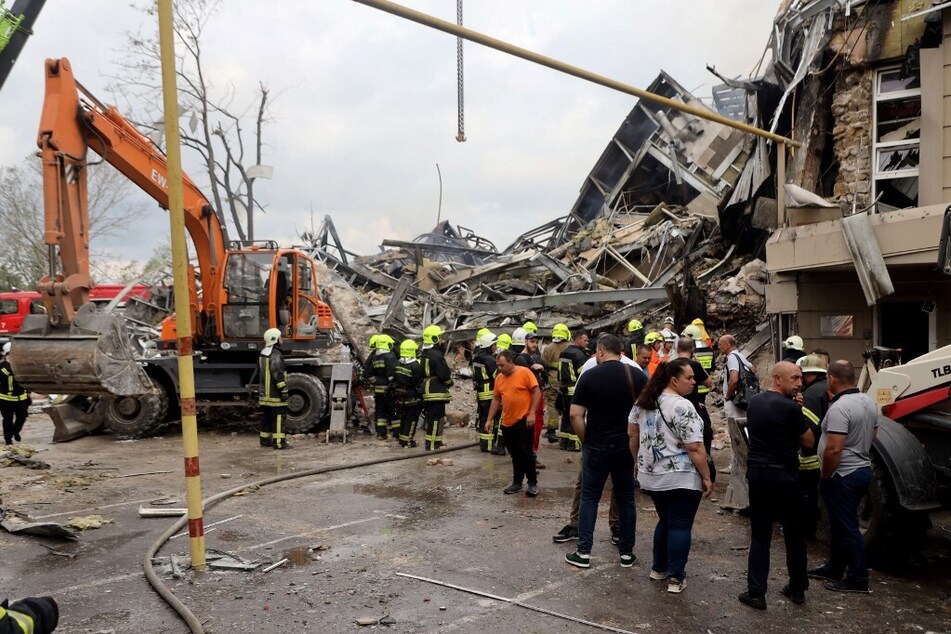 Ukrainian rescuers dismantle the rubble of a destroyed administrative building in the center of Odessa after a Russian missile strike on July 20, 2023.