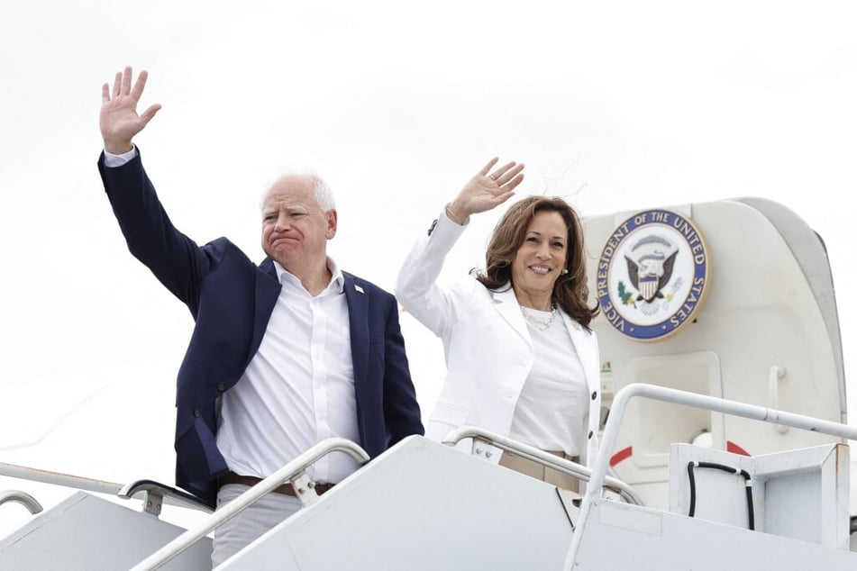 Democratic presidential nominee Kamala Harris (r.) and her running mate, Minnesota Governor Tim Walz, wave as they prepare to board Air Force Two.