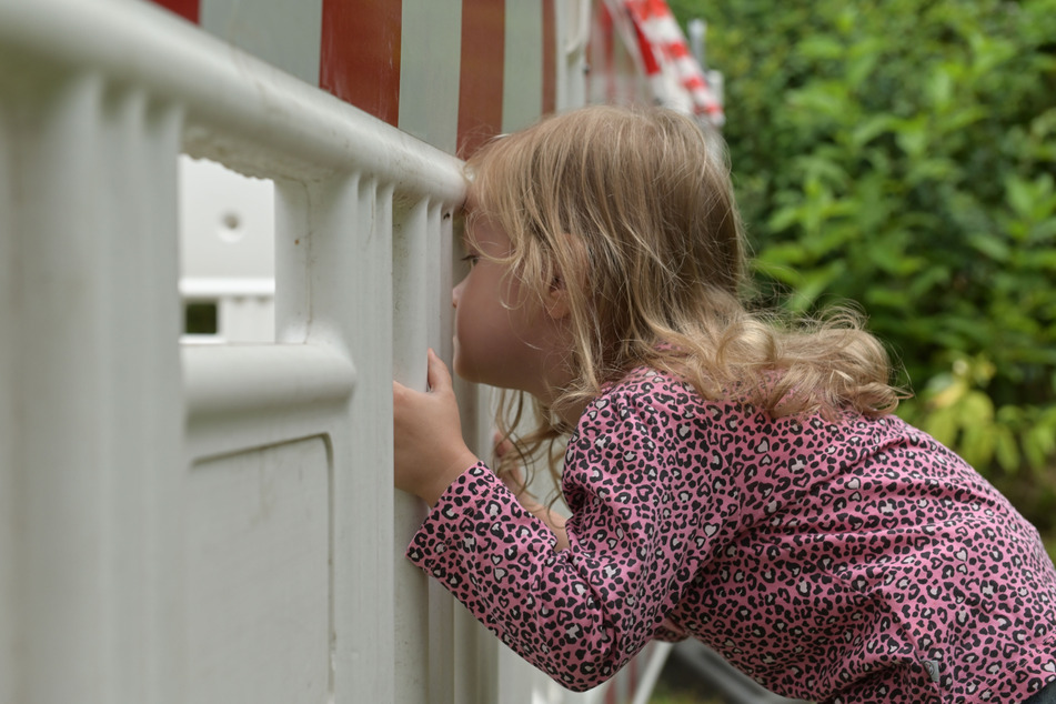 Scarlett (2) guckt sehnsüchtig durch die Absperrung auf die Rutsche, doch der Platz bleibt erstmal gesperrt.