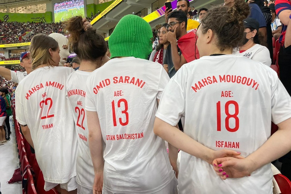 Eine Gruppe junger Frauen mit bunten Sturmhauben, die sich als Mitglieder des Kollektivs Pussy Riot zu erkennen geben, stehen während eines WM-Spiels auf der Tribüne.