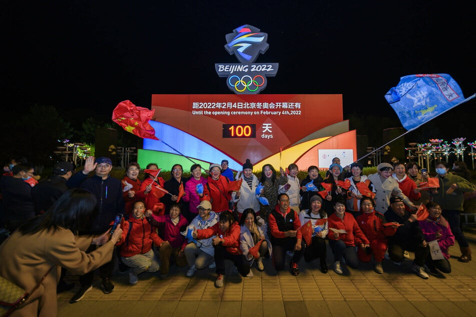 People pose for photos in front of a countdown clock in Zhangjiakou, Hebei Province.