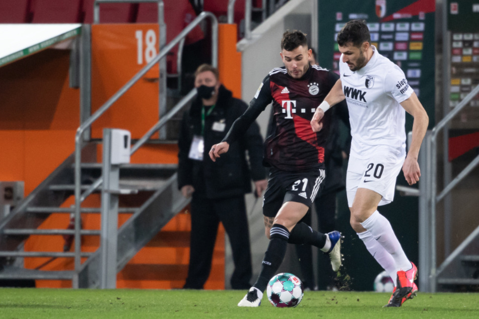 Bayerns Lucas Hernández (l.) im Duell mit Augsburgs Rechtsverteidiger Daniel Caligiuri.