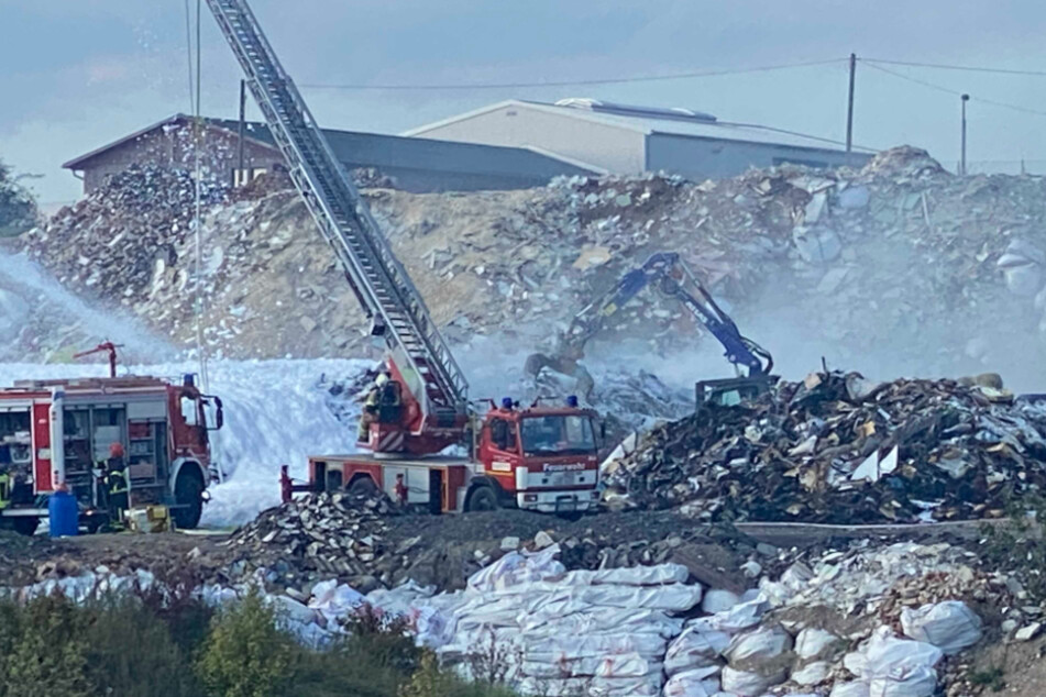 Feuerwehrleute bekämpfen den Brand mit Löschschaum.