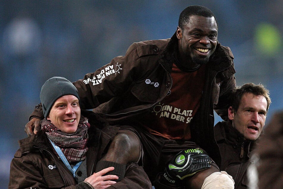 Timo Schultz (48, l) und Mathias Hain (52, r), die beide nicht im Kader waren, tragen den Derby-Torschützen Gerald Asamoah (46) auf ihren Schultern.