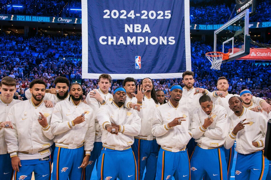 Oklahoma City Thunder players pose with their rings in front of the championship banner prior to the game against the Houston Rockets at Paycom Center on October 21, 2025.