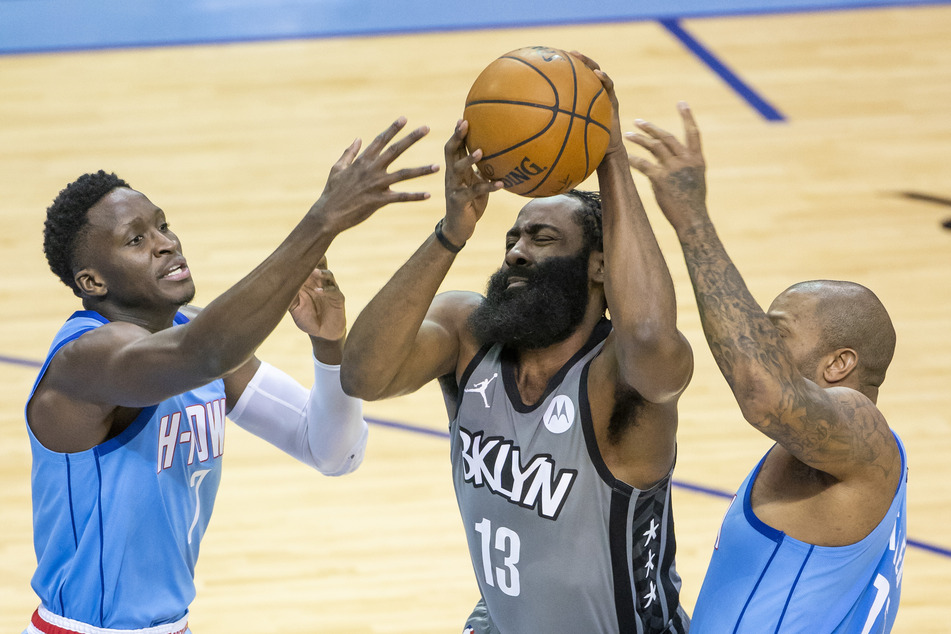 James Harden (M) von den Brooklyn Nets gegen Victor Oladipo (l) und P.J. Tucker (r) von den Houston Rockets.