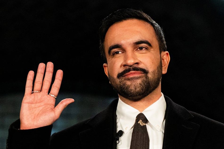 Zohran Mamdani raises his hand as he is sworn in as mayor of New York City at Old City Hall Station on January 1, 2026.