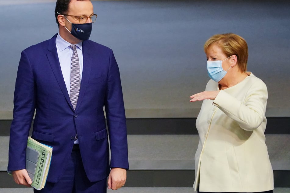 Bundeskanzlerin Angela Merkel (CDU), spricht mit Jens Spahn (CDU), Bundesminister für Gesundheit, im Bundestag vor Beginn der Debatte in der Haushaltswoche am 29. September.
