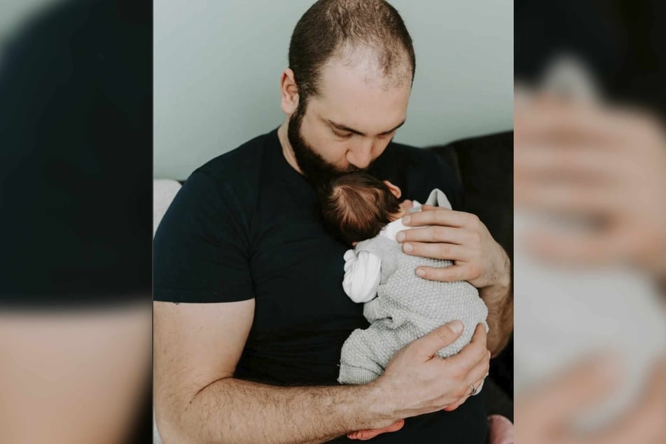Philipp (34) hält seinen Sohn im Arm.