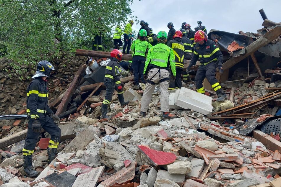 Rettungskräfte durchsuchen die Trümmer eines nach einem Murenabgang eingestürzten Bauernhauses in Fontanelice.