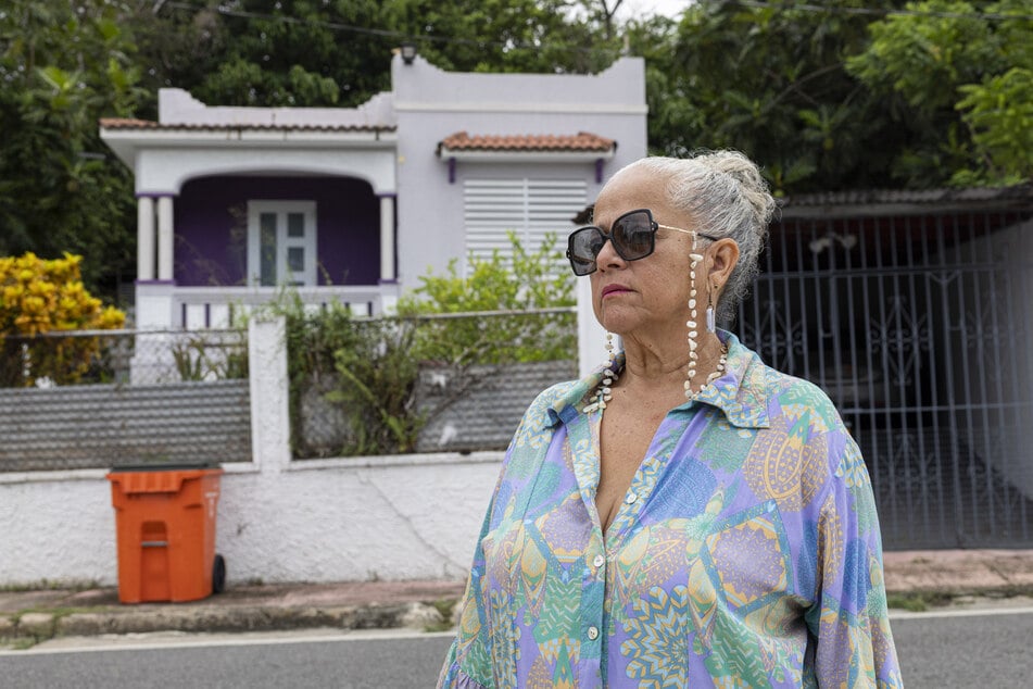 Gloria Cuevas poses for a photo in front of her former house after it was converted into an Airbnb in Rincon, Puerto Rico, on July 14, 2025.