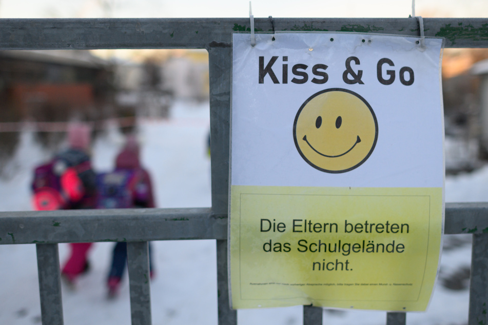 Das Schild mit einem Smiley und der Aufschrift "Die Eltern betreten das Schulgelände nicht" hängt am Tor der Regenbogenschule in Dresden.