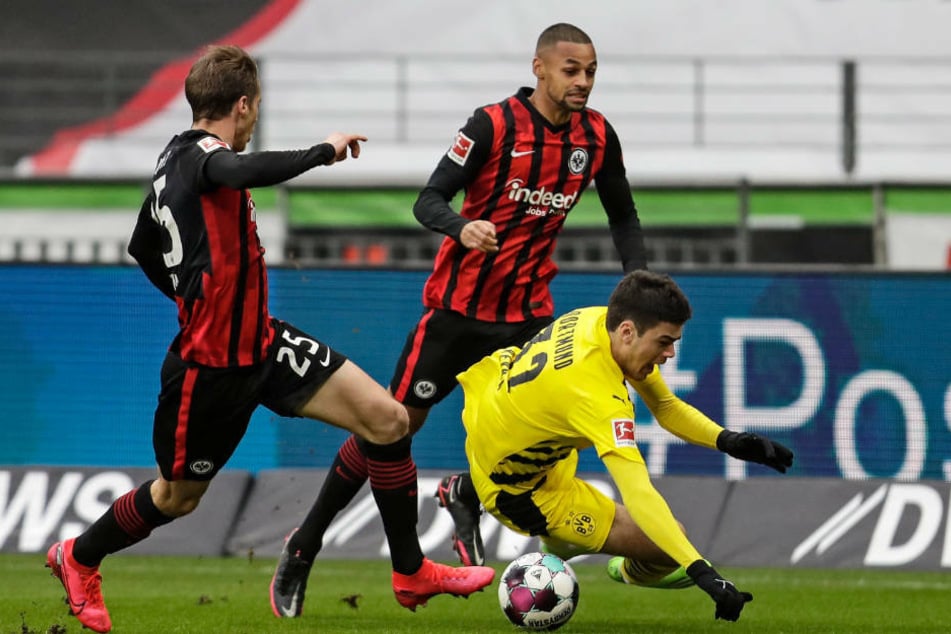 Die Frankfurter Erik Durm (l.) und Djibril Sow (M.) bringen Dortmunds Giovanni Reyna zu Fall.