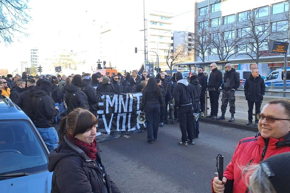 Schwarz gekleidete Rechtsextreme versammeln sich auf der Brückenstraße.