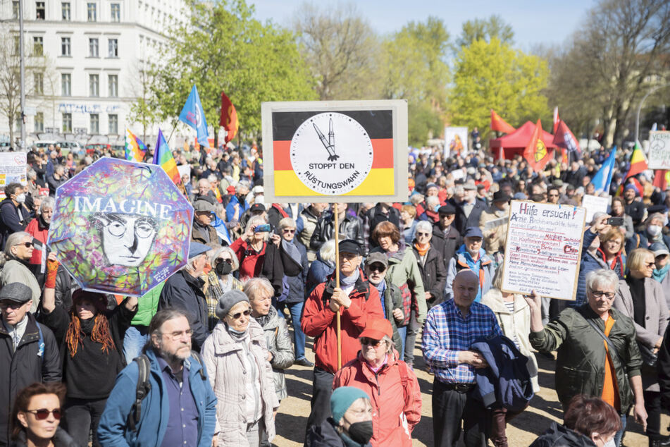 Demonstranten halten beim Ostermarsch des "Netzwerks Friedenskooperative" unter dem Motto "Die Waffen nieder!" am Oranienplatz in Berlin-Kreuzberg Schilder. Darauf ist unter anderem zu lesen "Stoppt den Rüstungswahn".