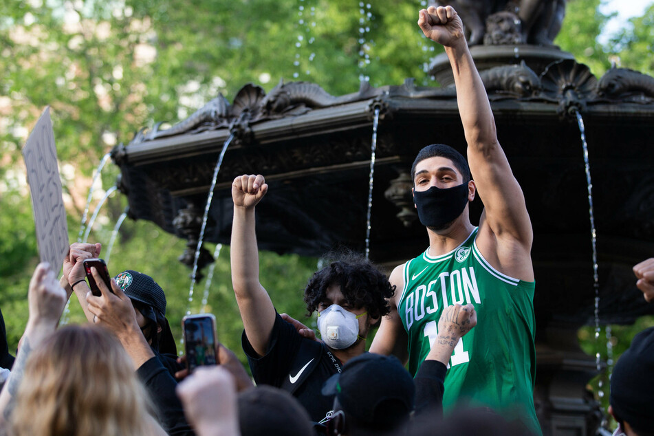 Enes Kanter (r) joins protesters at a 2020 rally for George Floyd in Boston.