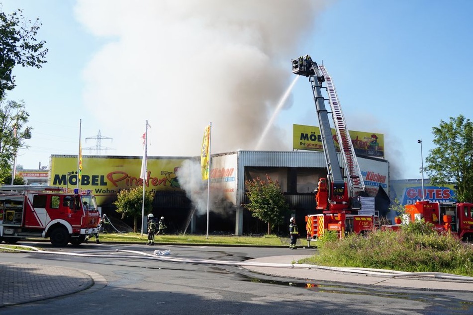 Beim Eintreffen der Feuerwehr schlugen die Flammen bereits deutlich aus dem Dach des brennenden Möbelhauses.