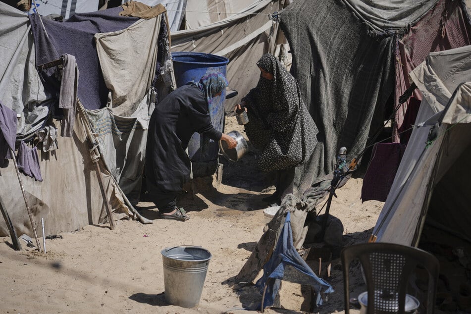 Vertriebene Palästinenser waschen ihr Geschirr in einem Zeltlager in Muwasi im südlichen Gazastreifen, einem Gebiet, das Israel als sichere Zone ausgewiesen hat.